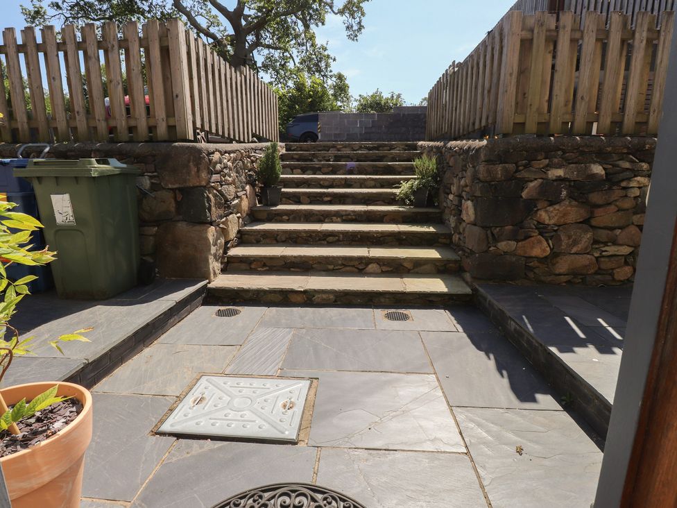 An outdoor area with steps and a stone fence at Wern Olau Cottage Groeslon near Caernarfon