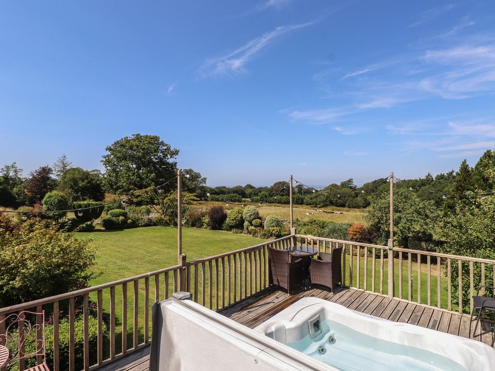 A garden with a hot tub and outdoor furniture at Wern Olau Cottage in Groeslon near Caernarfon
