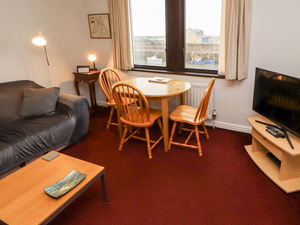 A living room with a table and chairs at Harbour Side in Maryport