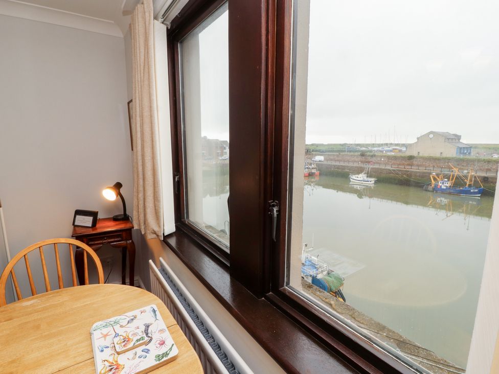 A dining room with a table and window view at Harbour Side in Maryport