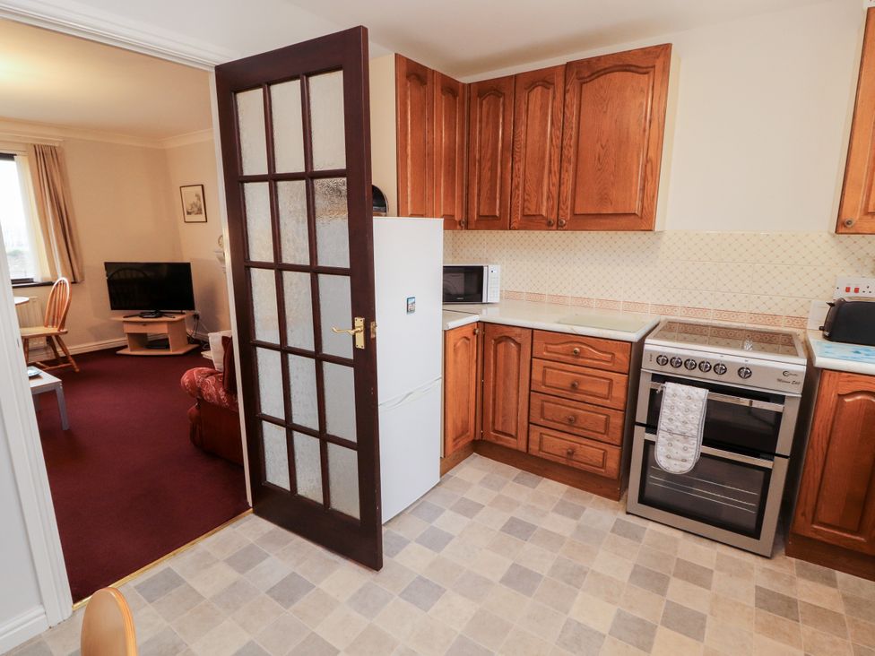 A kitchen with an oven and refrigerator at Harbour Side in Maryport
