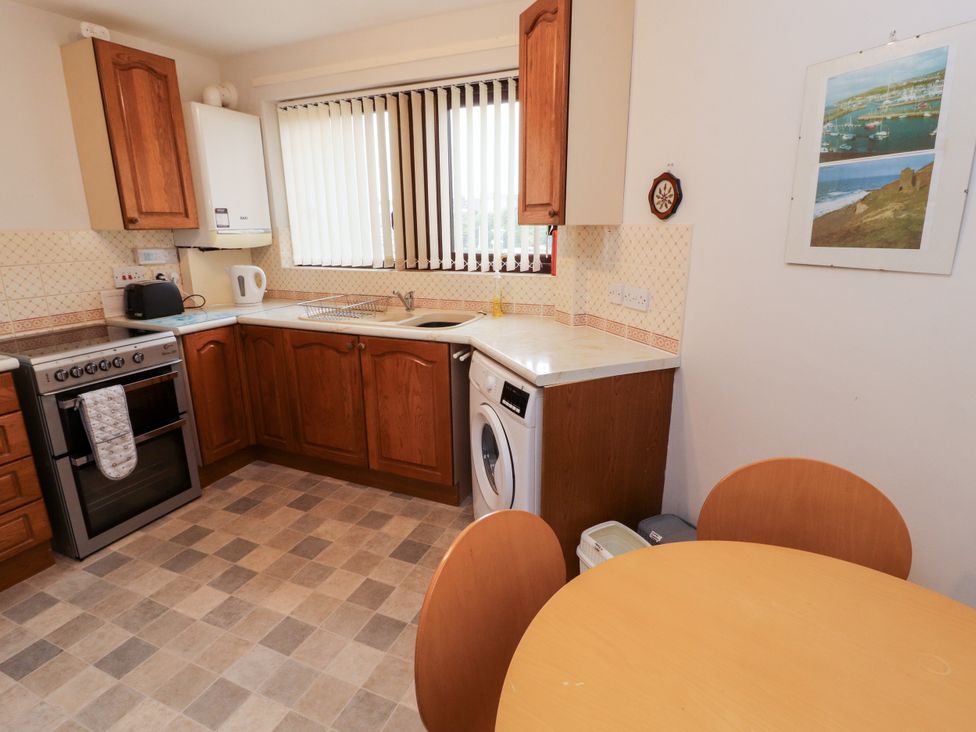 A kitchen with a table and chairs at Harbour Side in Maryport