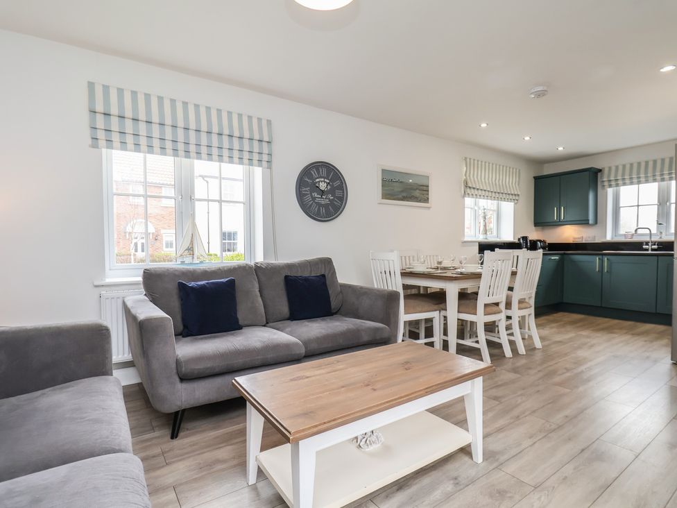 A living room with a sofa and dining area at Coastal Cottage The Bay near Filey
