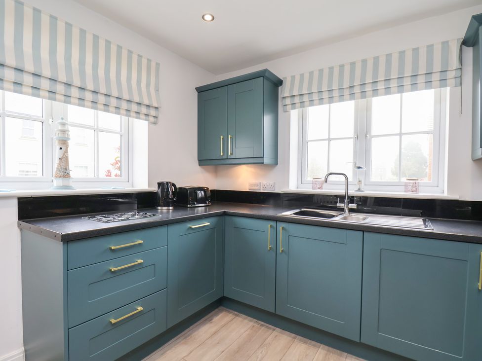 A kitchen with cabinets and a sink at Coastal Cottage The Bay near Filey