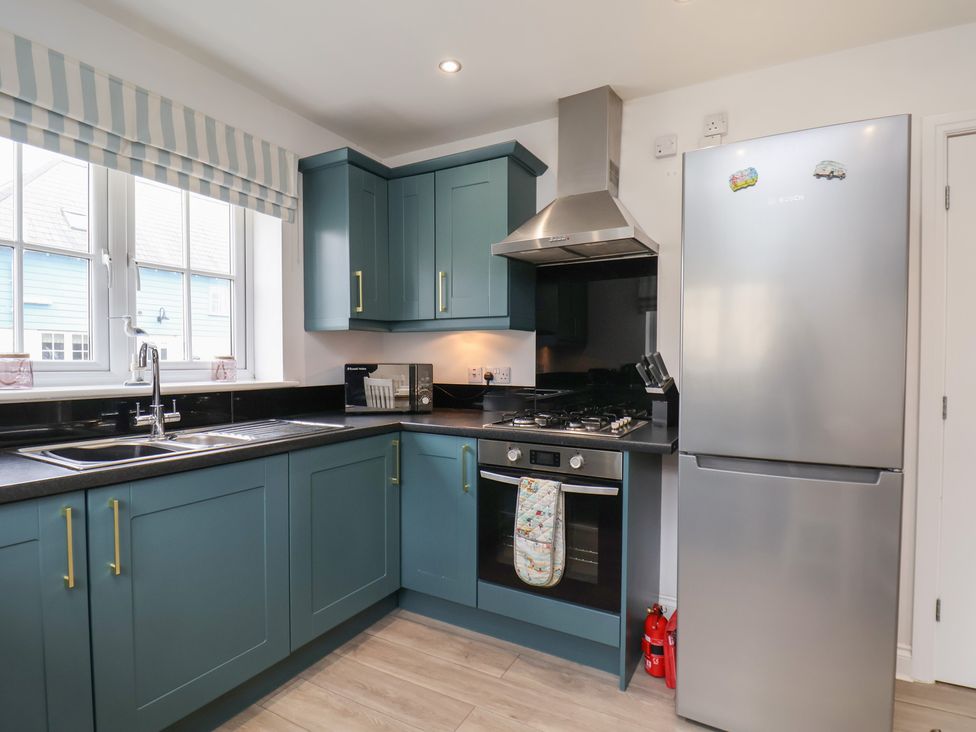 A kitchen with a sink, cooker, and fridge at Coastal Cottage The Bay near Filey