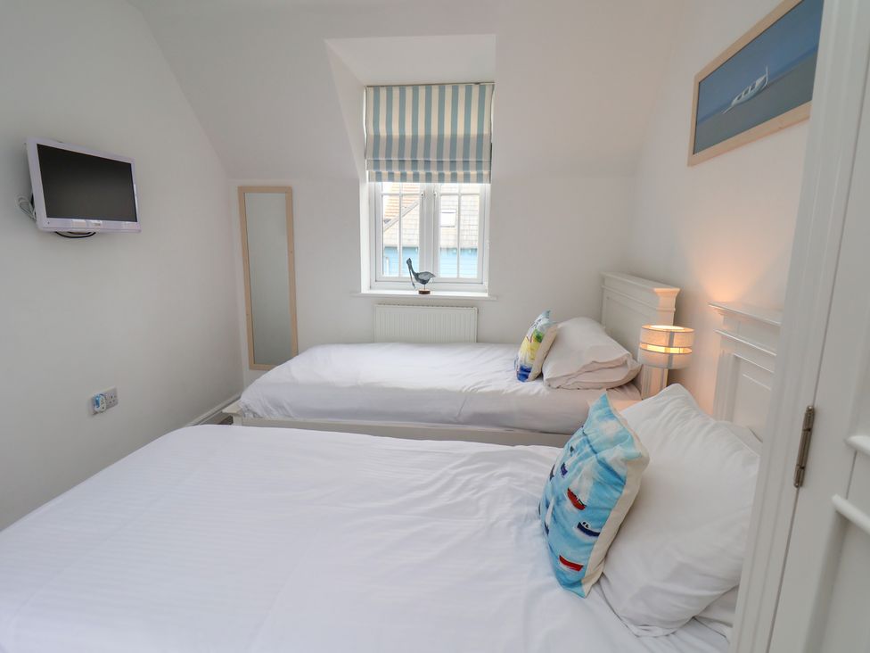 A bedroom with two beds and a television at Coastal Cottage The Bay near Filey