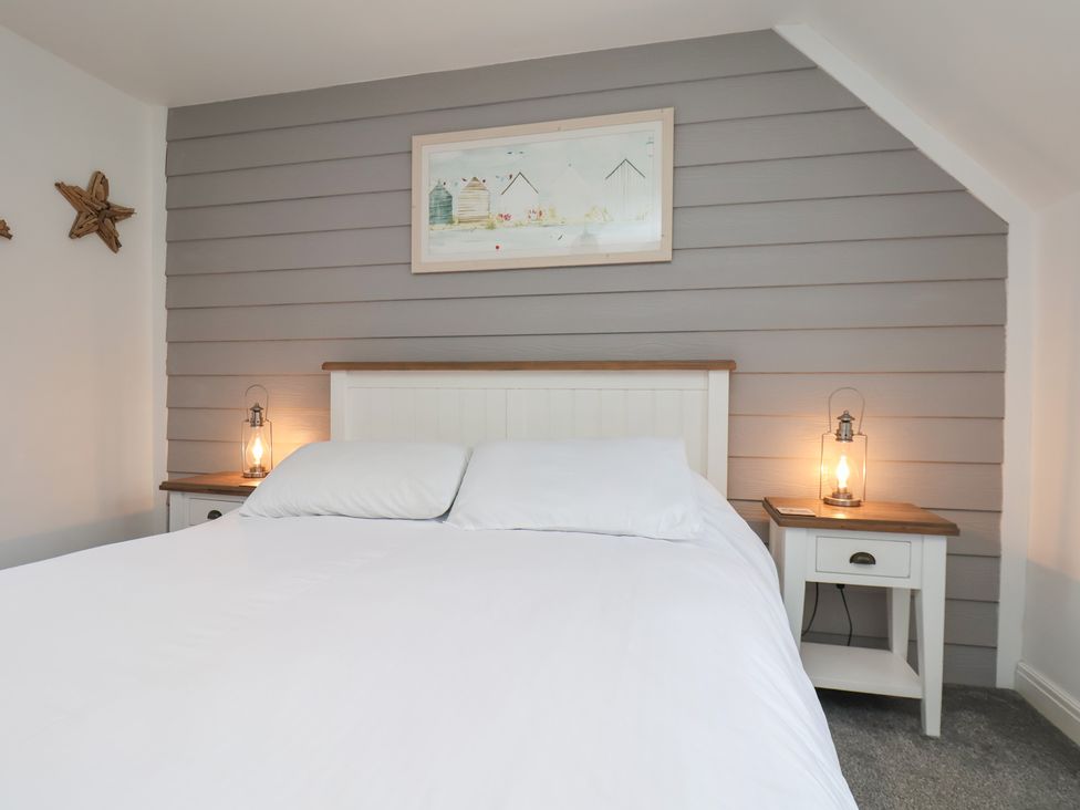 A bedroom with a bed and nightstands at Coastal Cottage The Bay near Filey