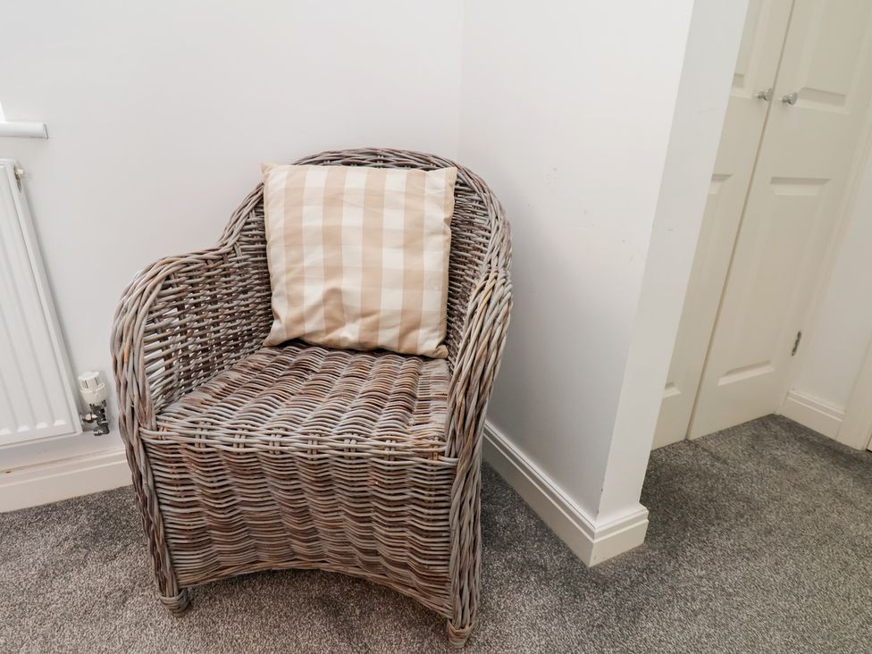 A chair with a cushion in a room at Coastal Cottage The Bay near Filey