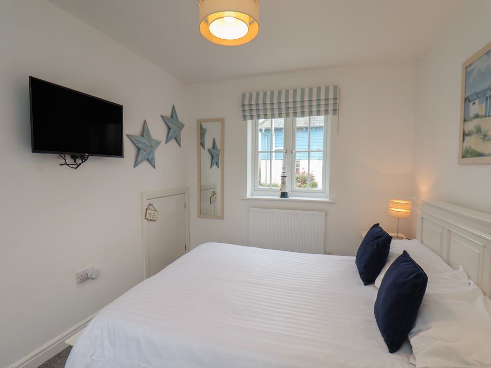 A bedroom with a bed and television at Coastal Cottage The Bay near Filey