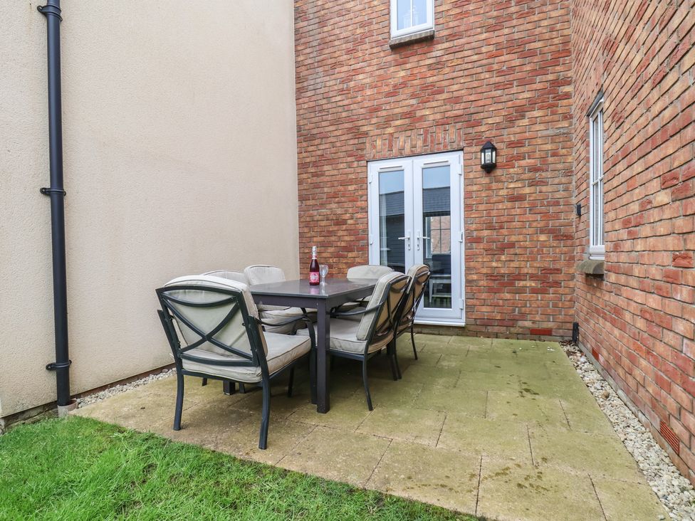 An outdoor dining area with a table and chairs at Coastal Cottage The Bay near Filey