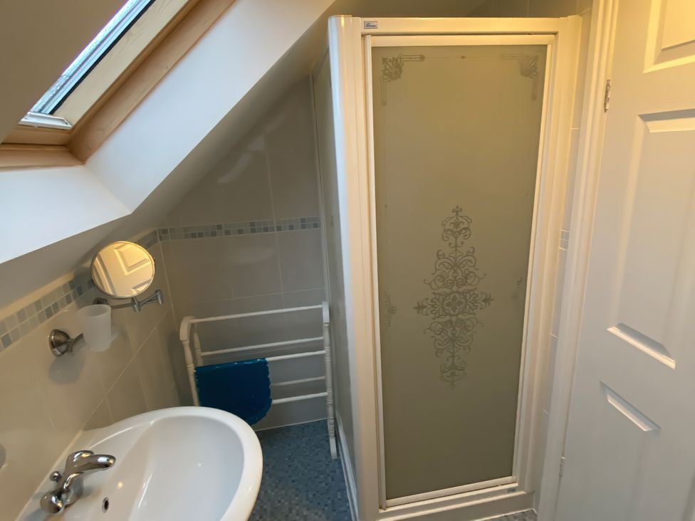 A bathroom with a shower, sink, and towel rack at The Old Cider Barn in Wookey