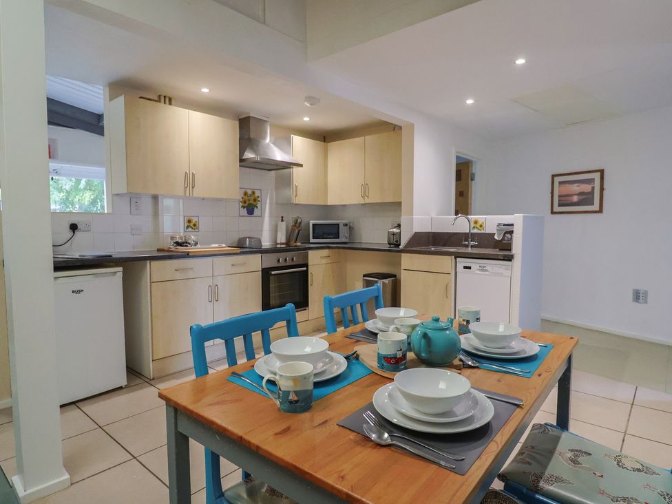 A kitchen with a dining table and chairs at Brookfield Lodge in Drimpton