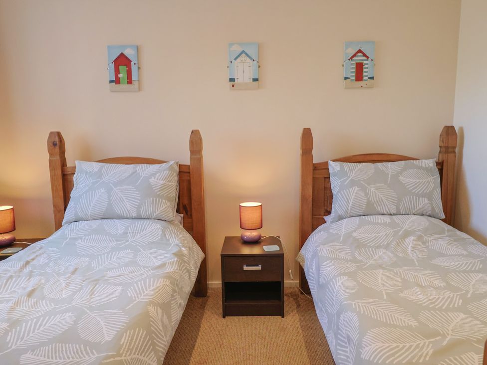 A bedroom with two beds and wall art at Brookfield Lodge in Drimpton