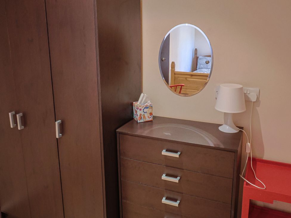 A bedroom with a mirror and lamps at Brookfield Lodge in Drimpton