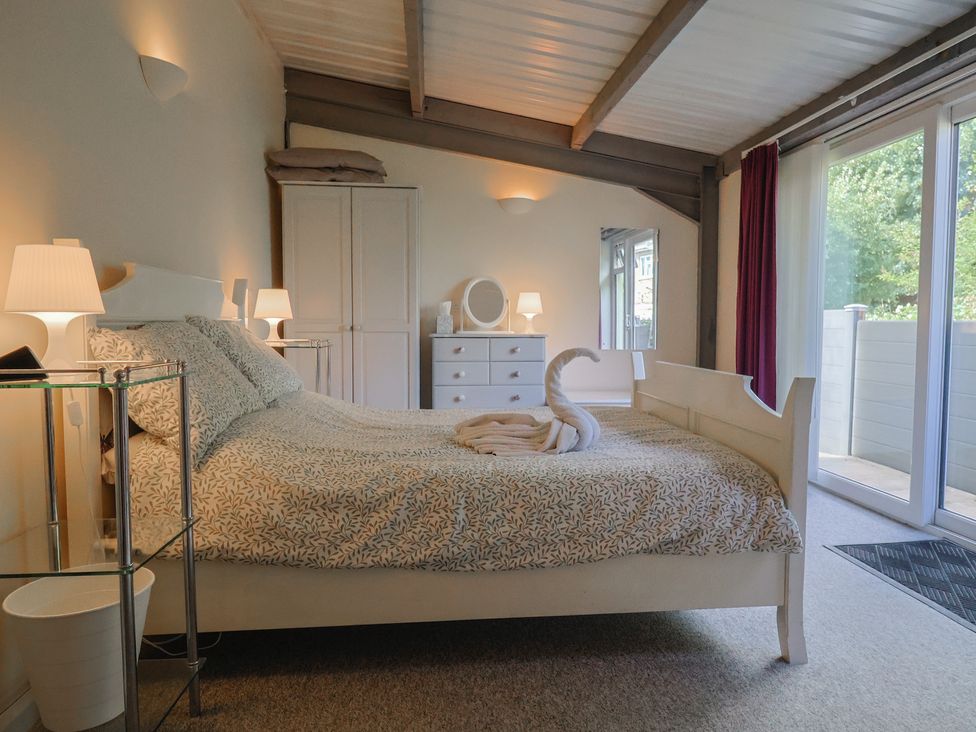 A bedroom with a bed and a dresser at Brookfield Lodge in Drimpton
