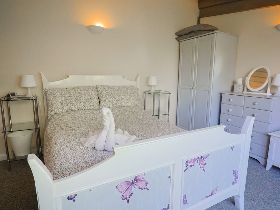 A bedroom with a bed and side furniture at Brookfield Lodge in Drimpton