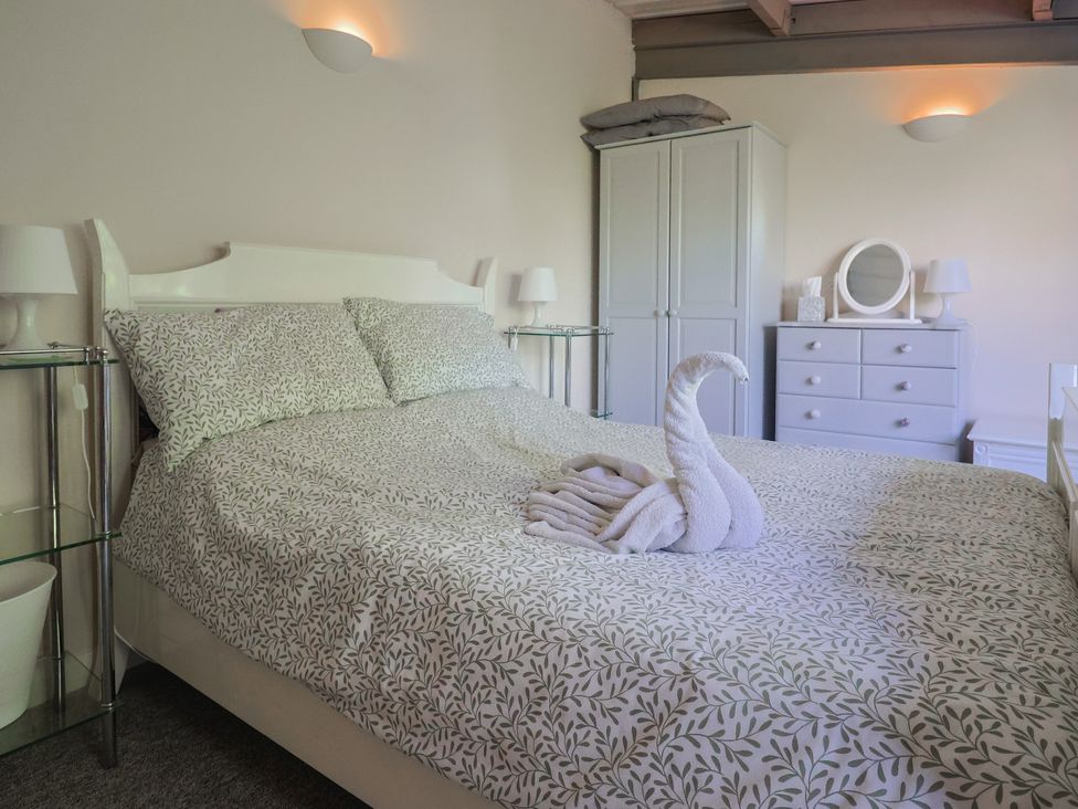 A bedroom with a bed and a wardrobe at Brookfield Lodge in Drimpton