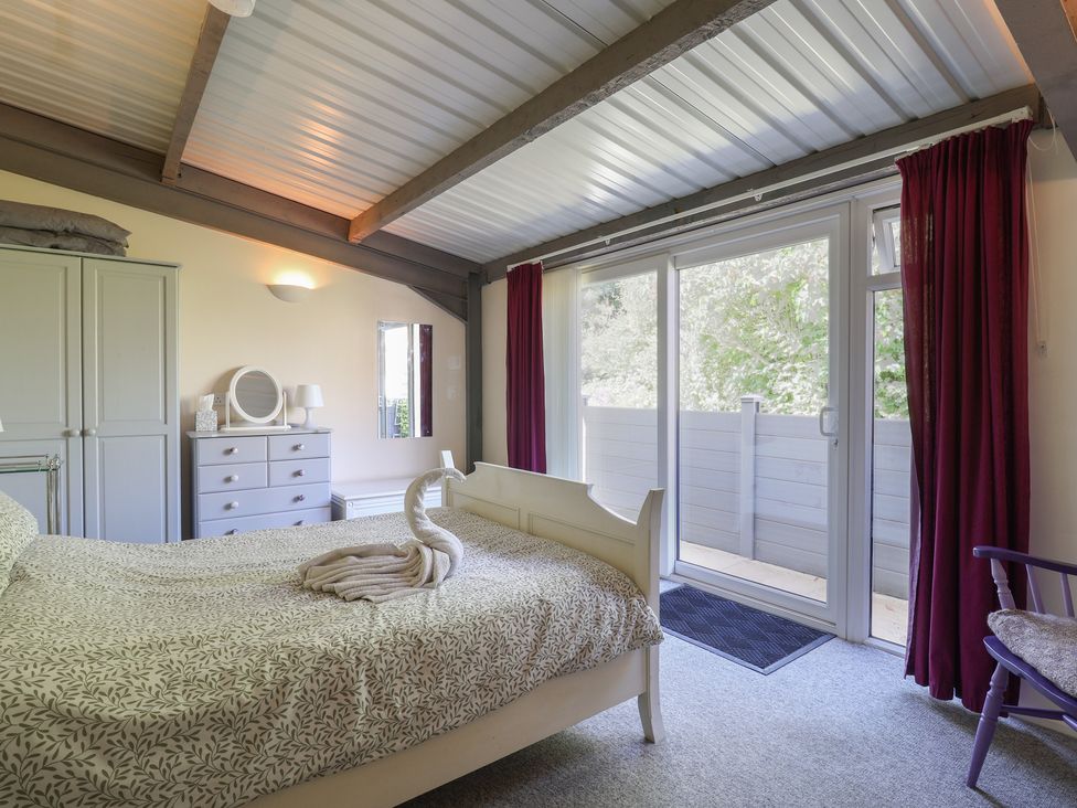 A bedroom with a bed and wardrobe at Brookfield Lodge in Drimpton