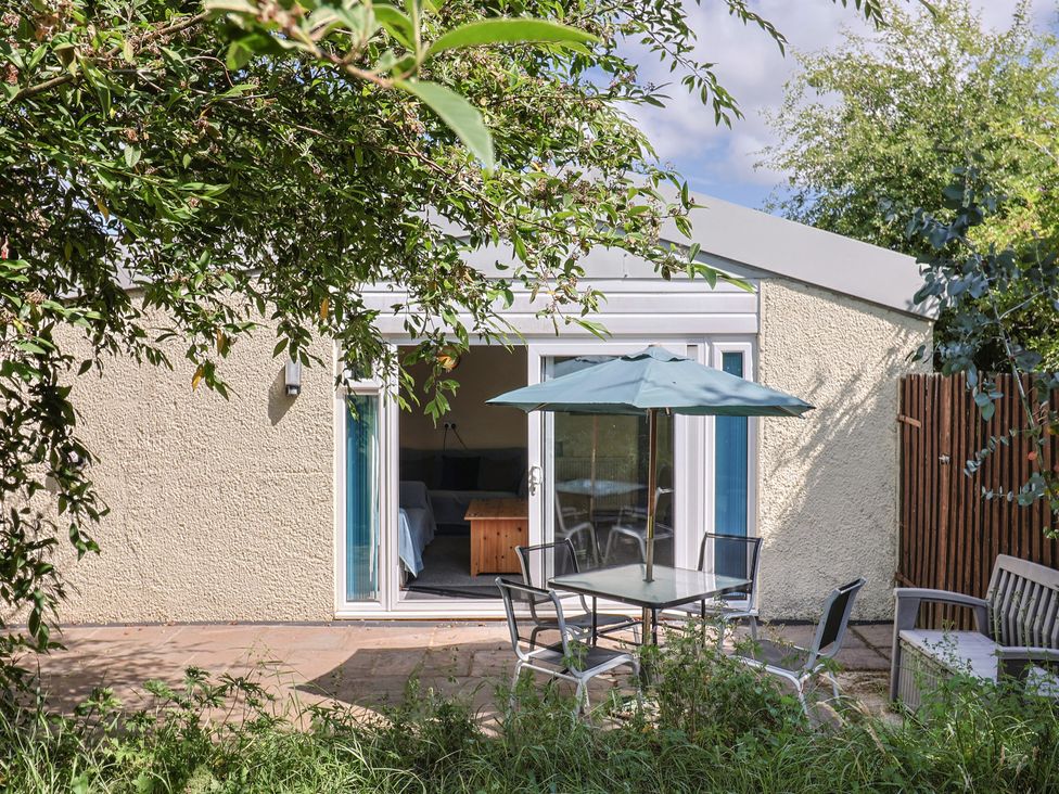 A patio area with a table and chairs at Brookfield Lodge in Drimpton