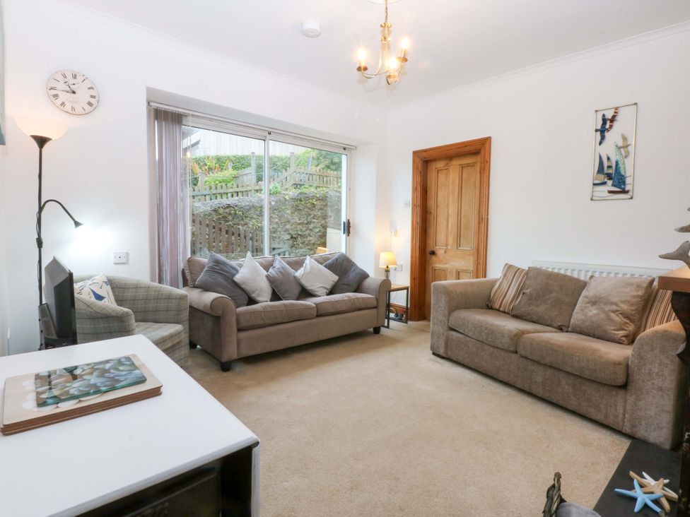 A living room with two sofas and a television at 2 Argoed Llanbedrog
