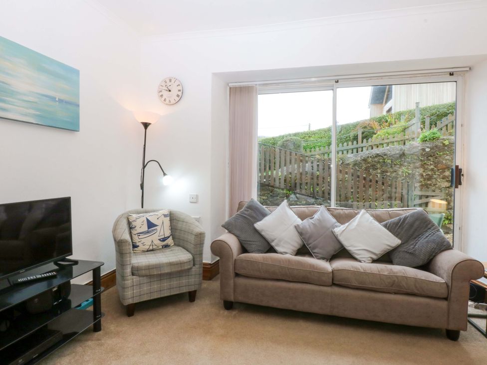 A living room with a sofa and armchair at 2 Argoed Llanbedrog