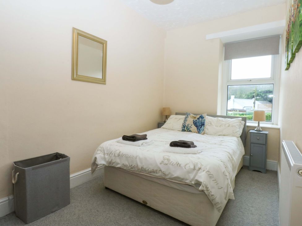 A bedroom with a bed and a window at 2 Argoed Llanbedrog