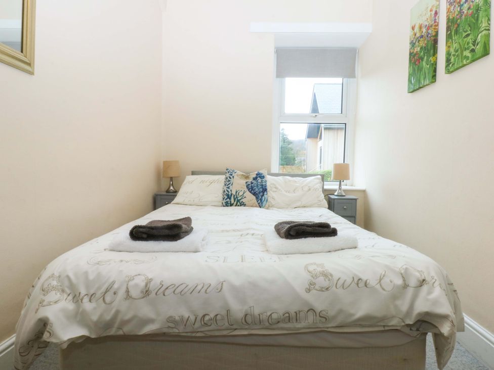 A bedroom with a bed and bedside table at 2 Argoed Llanbedrog