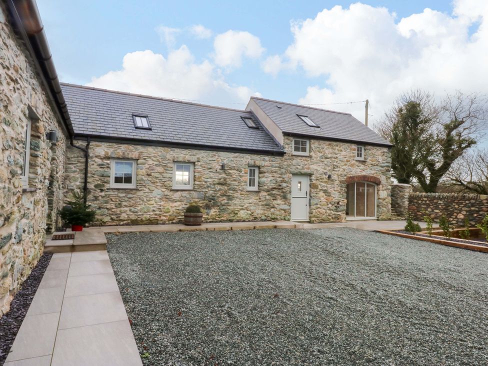 An outdoor area with a stone building and gravel ground at Storws Tanrallt