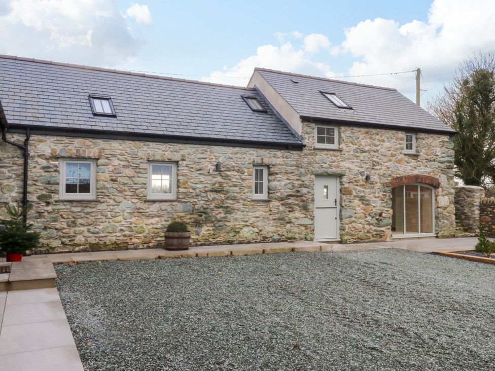 A stone cottage with a gravel yard at Storws Tanrallt 