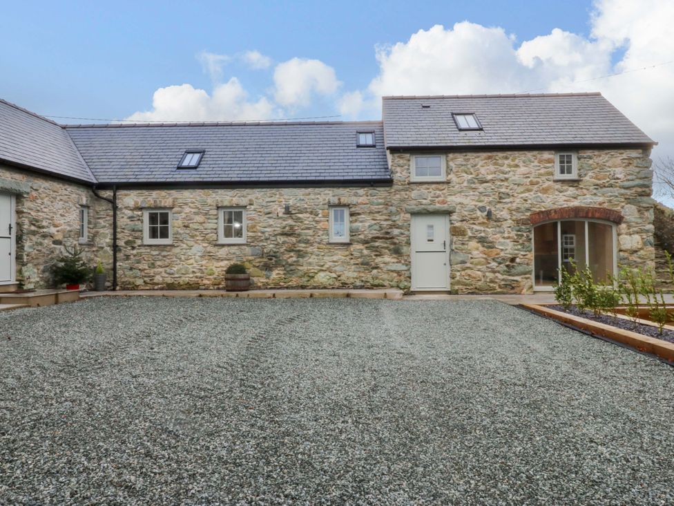 An outdoor area with stone walls and gravel at Storws Tanrallt