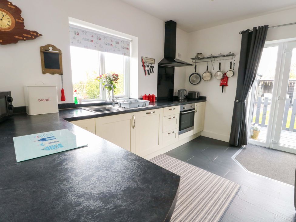 A kitchen with a sink and cabinets at Hafod Wen in Pentraeth