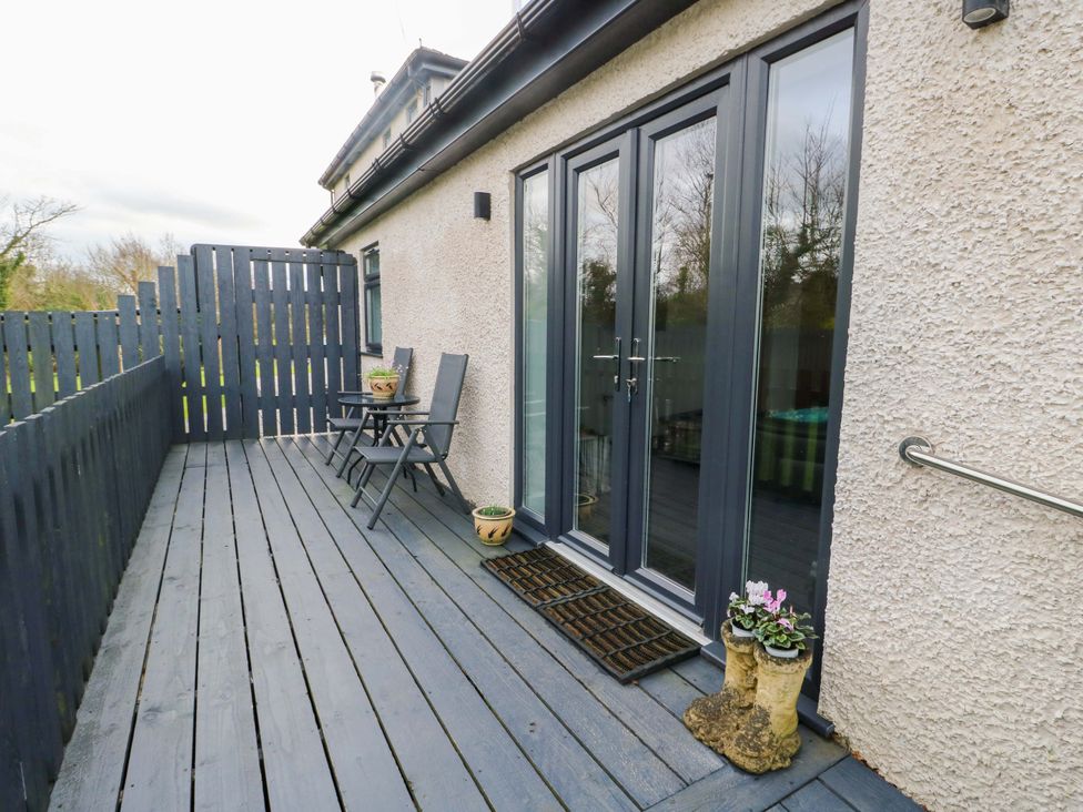 An outdoor space with seating and flower pots at Hafod Wen in Pentraeth