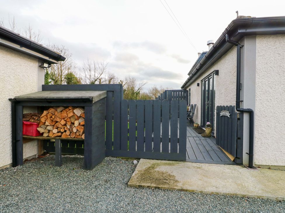 An outdoor area with wood storage and a fence at Hafod Wen Pentraeth