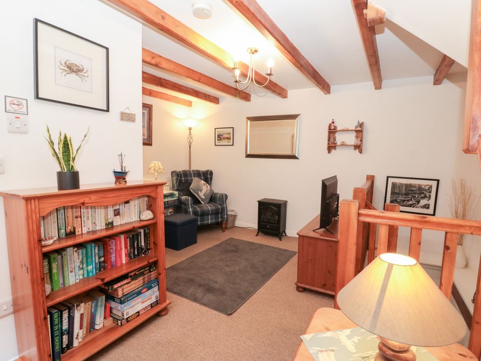 A living room with a bookshelf and a sofa at The Old Cottage in Staithes