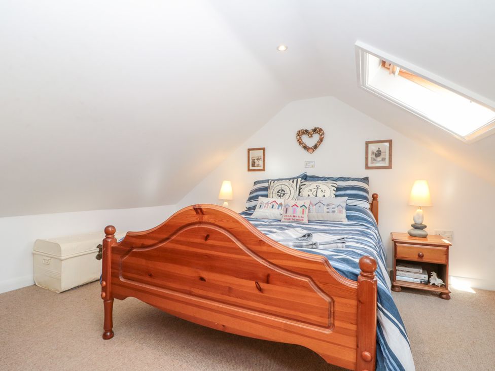A bedroom with a wooden bed and nightstand at The Old Cottage in Staithes