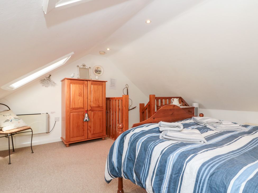 A bedroom with a bed and wardrobe at The Old Cottage in Staithes