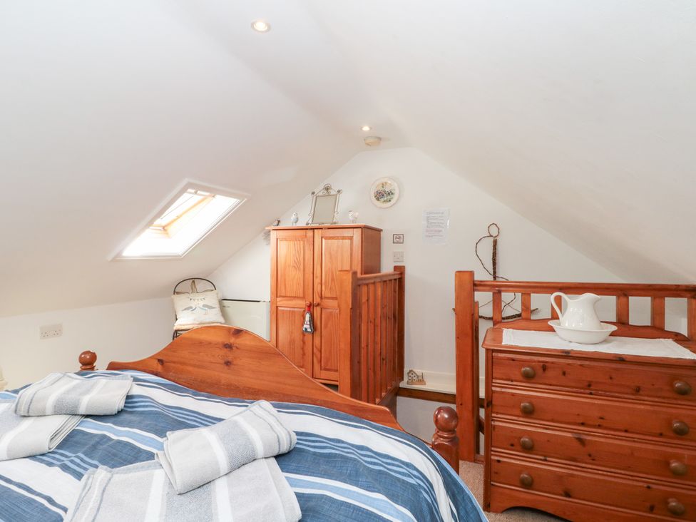 A bedroom with a bed and wooden furniture at The Old Cottage in Staithes