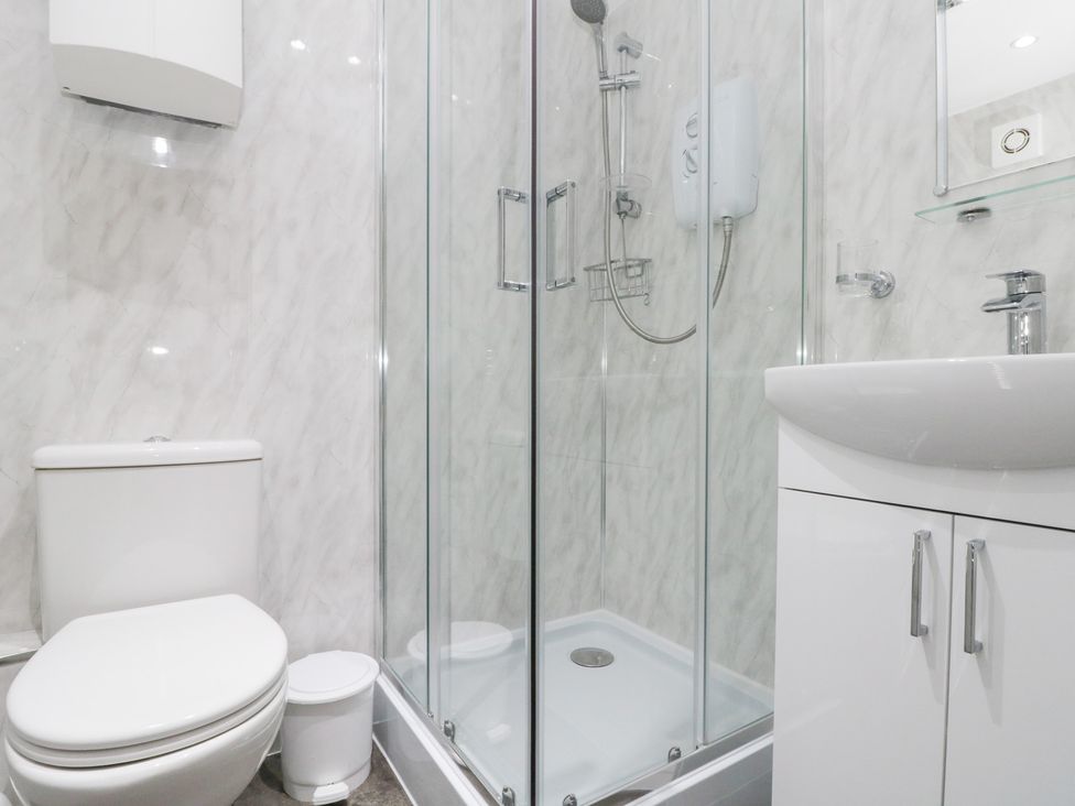 A bathroom with a shower enclosure and toilet at The Old Cottage in Staithes