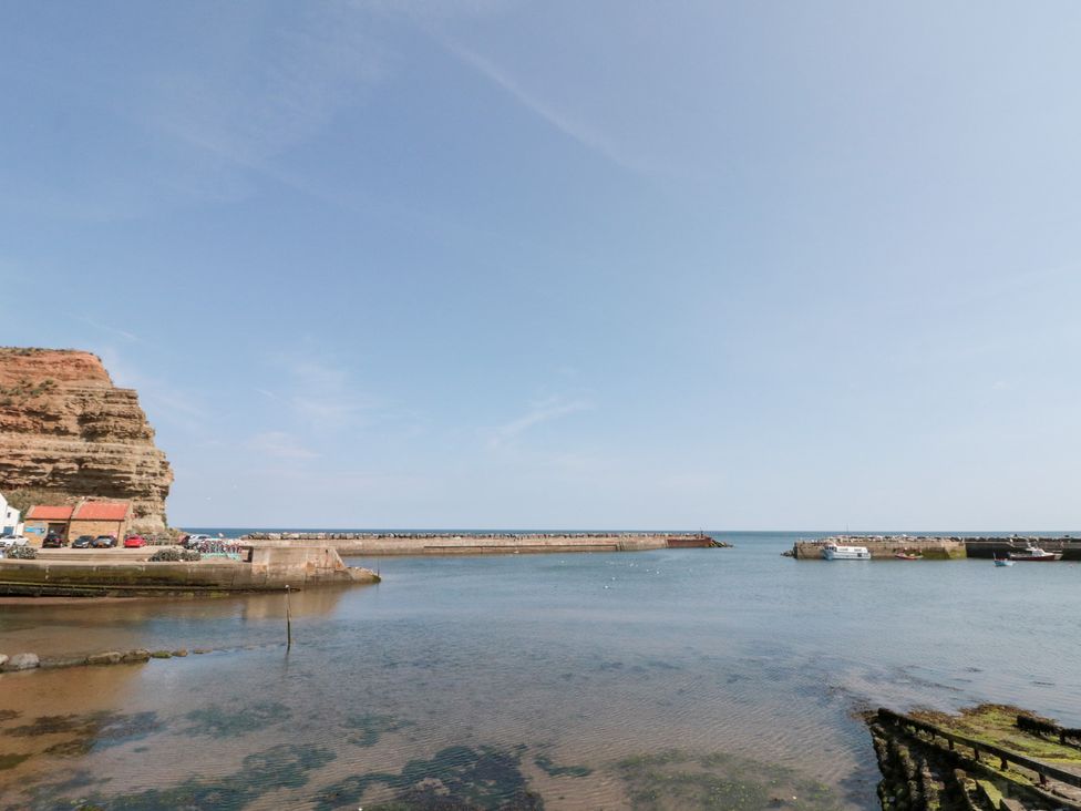A harbor with boats and cliffs at The Old Cottage in Staithes
