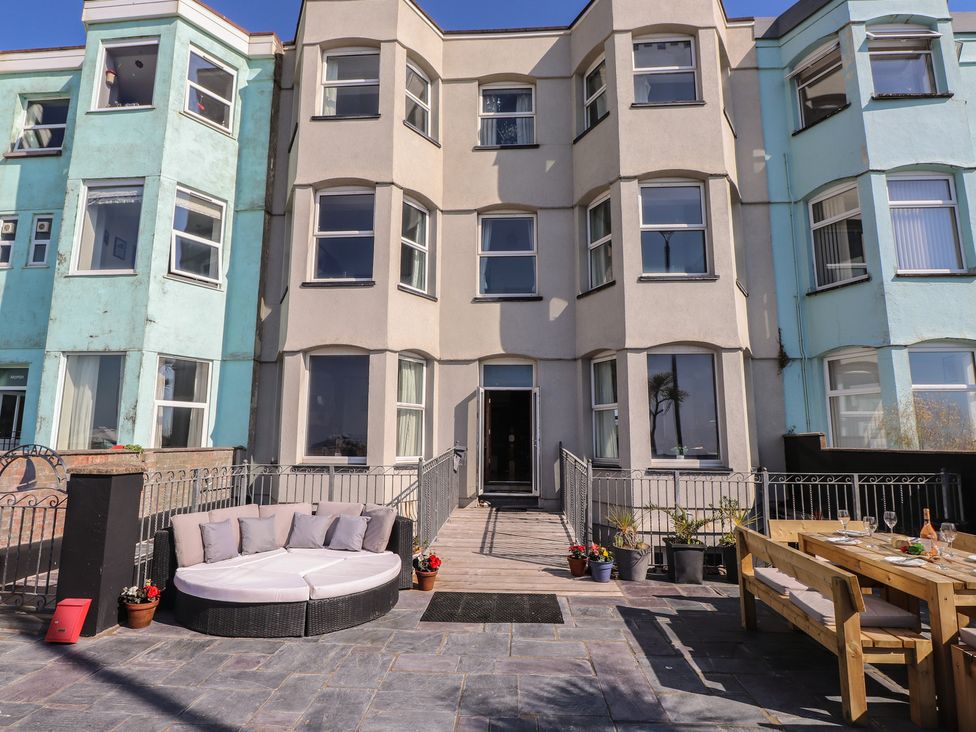 An outdoor area with seating and a dining table at Wavecrest in Pwllheli