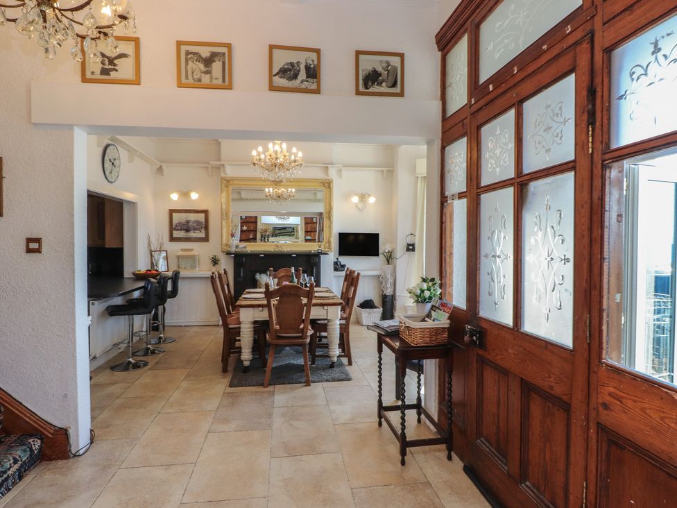 A dining room with a table and chairs at Wavecrest in Pwllheli