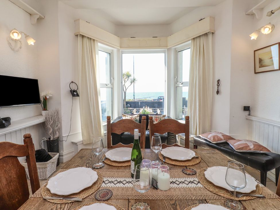 A dining room with a table set up at Wavecrest in Pwllheli