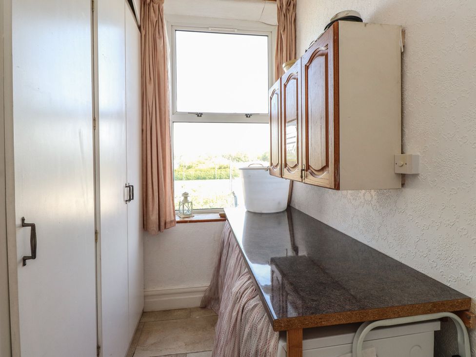 A utility room with a window and a countertop at Wavecrest in Pwllheli