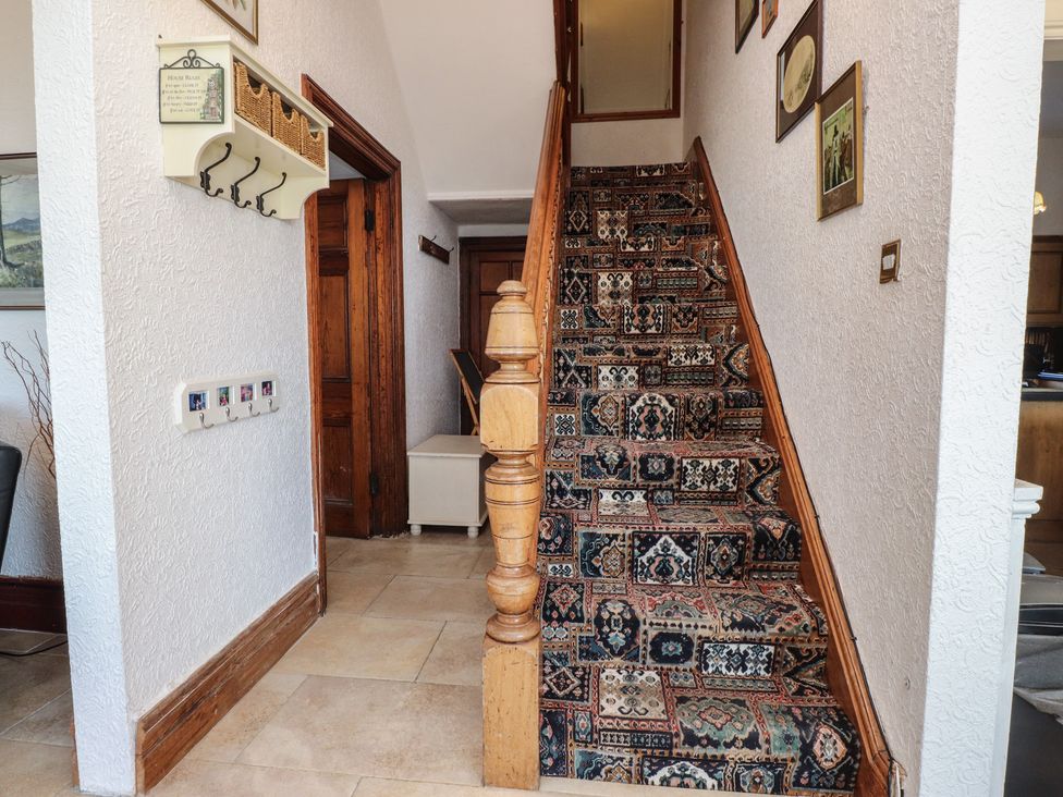 A staircase and wall hooks in a hallway at Wavecrest in Pwllheli