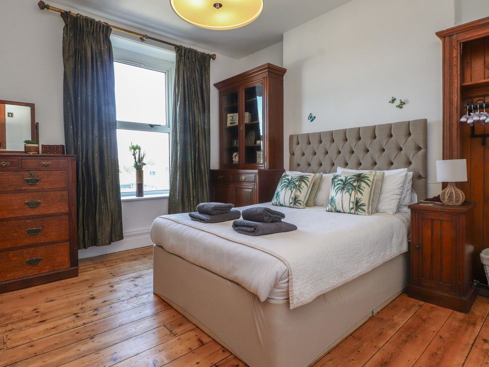 A bedroom with a bed, dresser, and window at Wavecrest in Pwllheli
