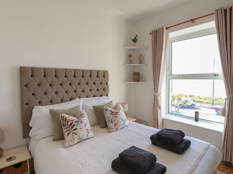 A bedroom with a bed and decorative pillows at Wavecrest in Pwllheli