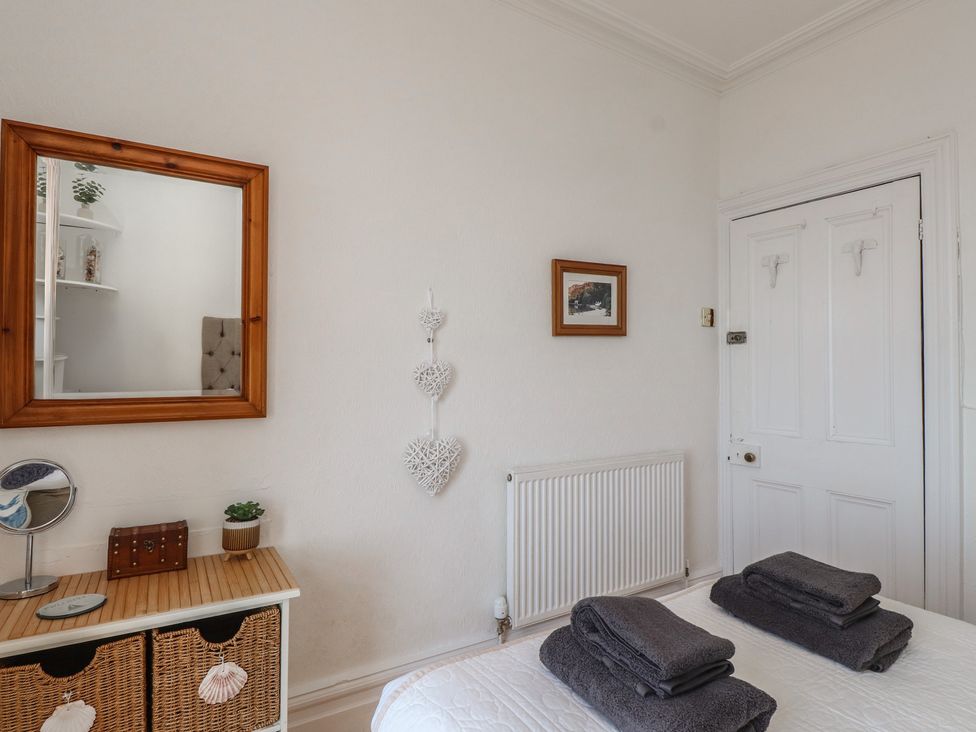 A bedroom with towels on the bed at Wavecrest in Pwllheli