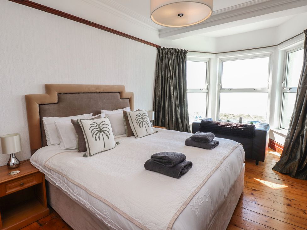 A bedroom with a bed and bedside table at Wavecrest in Pwllheli