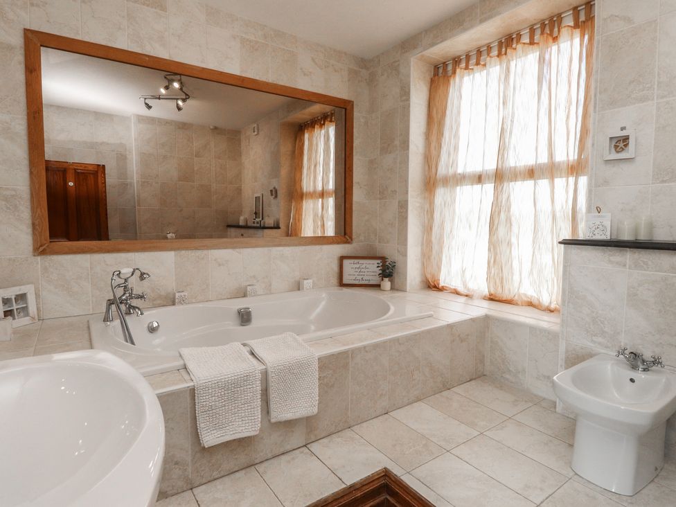 A bathroom with a bathtub and toilet at Wavecrest in Pwllheli