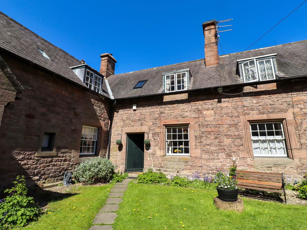 A cottage with a garden and pathway at Gamekeepers Cottage in Chillingham near Chatton